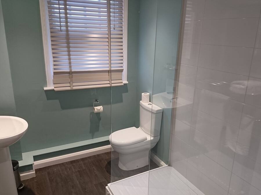 Ein Badezimmer mit Toilette, Waschbecken und einer Duschkabine aus Glas.
