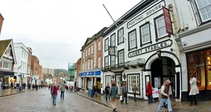 A street with a building labeled "POSTING HOUSE" and "LIVERY STABLES." - Angel Hotel (Guildford)