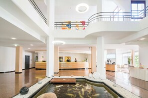Experience the tranquil atmosphere of our lobby, featuring a serene water feature and abstract art.