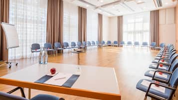 A conference room with a long table, chairs, a whiteboard, and a water dispenser.