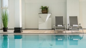 A swimming pool with two lounge chairs and a potted plant. - Best Western Plus Hotel Am Schlossberg (Nuertingen)
