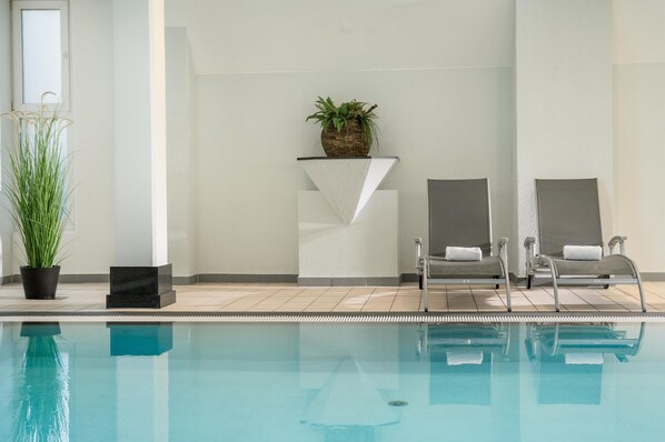 A swimming pool with two lounge chairs and a potted plant. - Best Western Plus Hotel Am Schlossberg (Nuertingen)