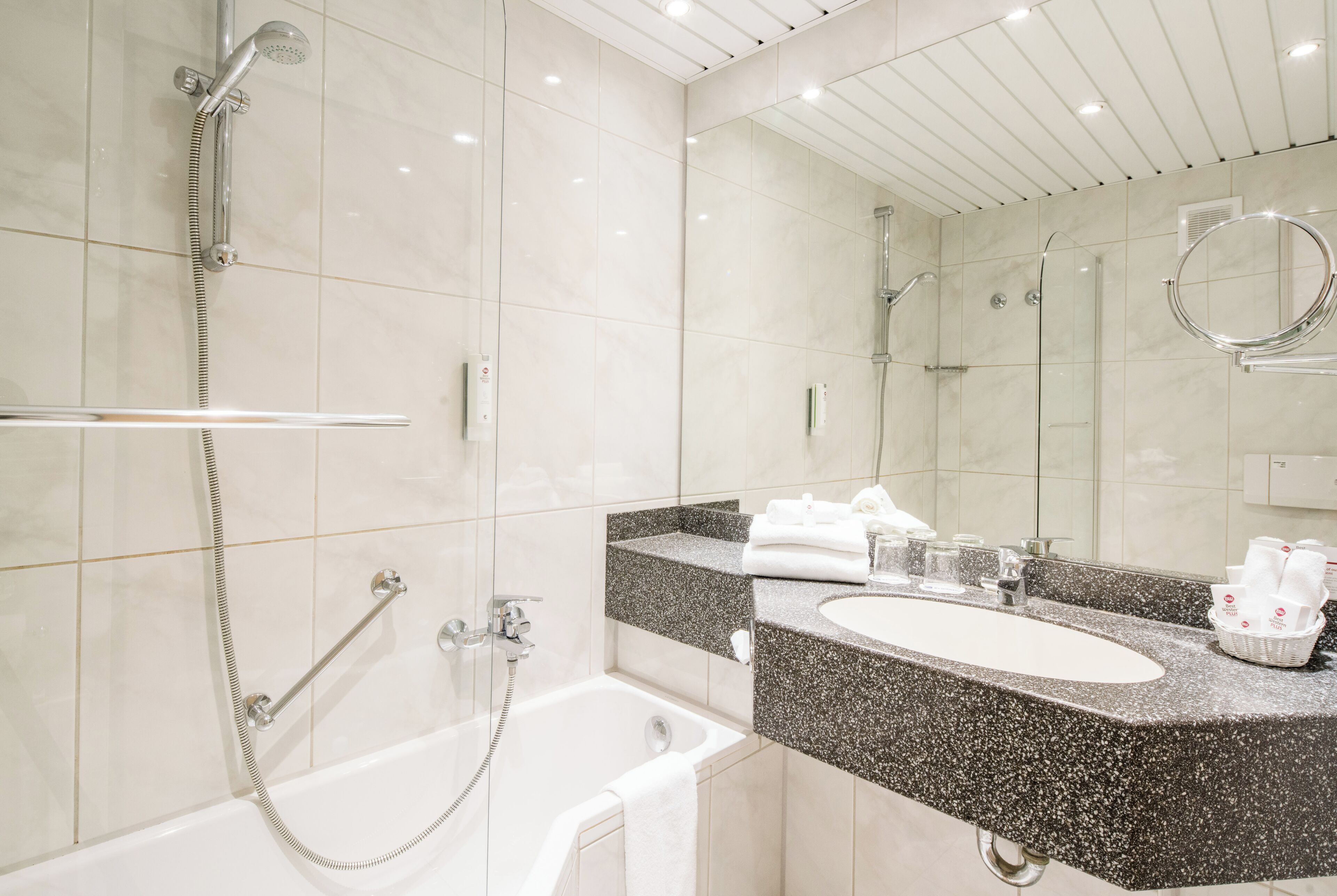 A modern bathroom with a bathtub, a shower, and a vanity with a sink.