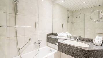A modern bathroom with a bathtub, a shower, and a vanity with a sink.