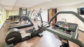 A gym with various exercise equipment including treadmills, a stationary bike, and weight machines.