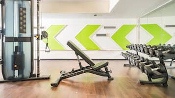 A gym with exercise equipment, including a bench press and dumbbells.