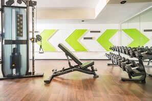 A gym with exercise equipment, including a bench press and dumbbells. - Best Western Plus Hotel Am Schlossberg (Nuertingen)