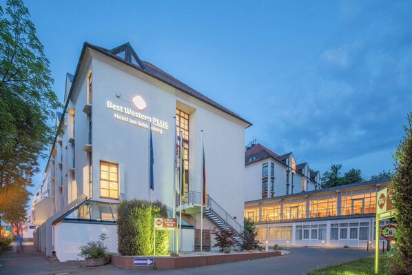 Experience the charm of this hotel, featuring a modern design with large and small windows, balconies on upper floors, and a welcoming entrance.