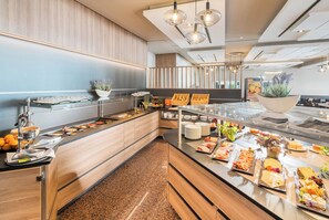 A buffet setup with various food items and a seating area. - Best Western Plus Hotel Am Schlossberg (Nuertingen)