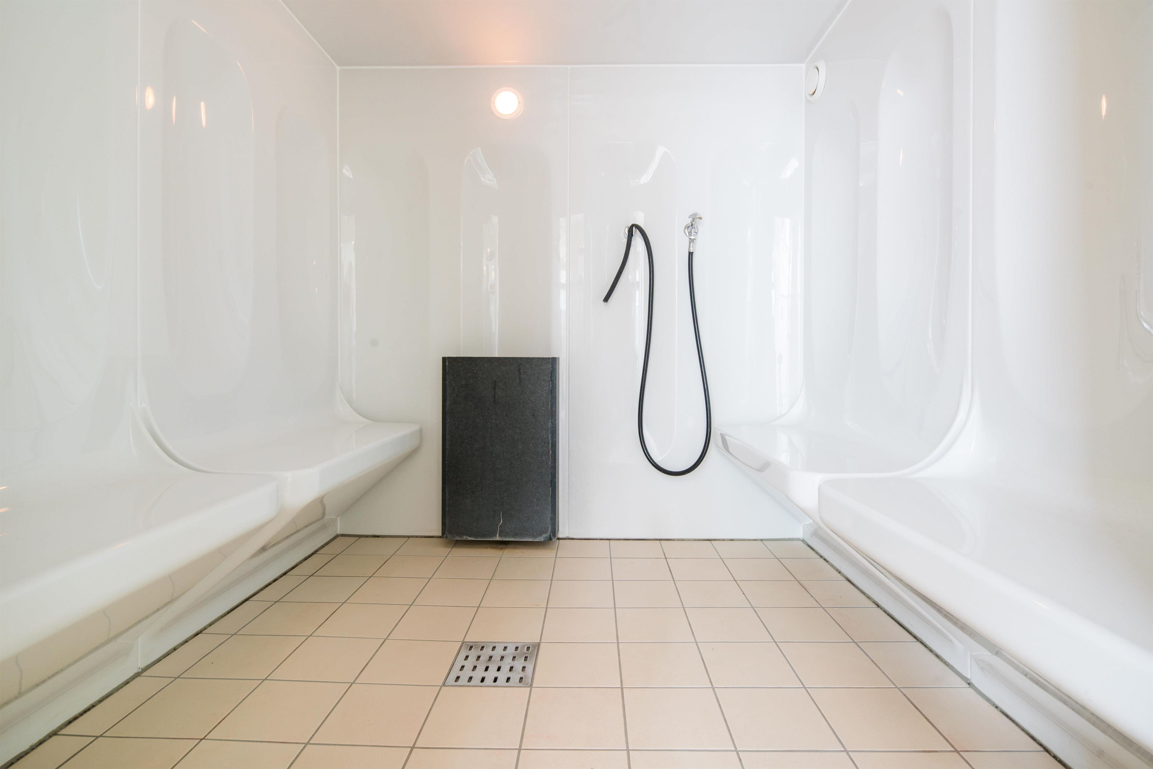 Un bagno con doccia, servizi igienici e scarico.