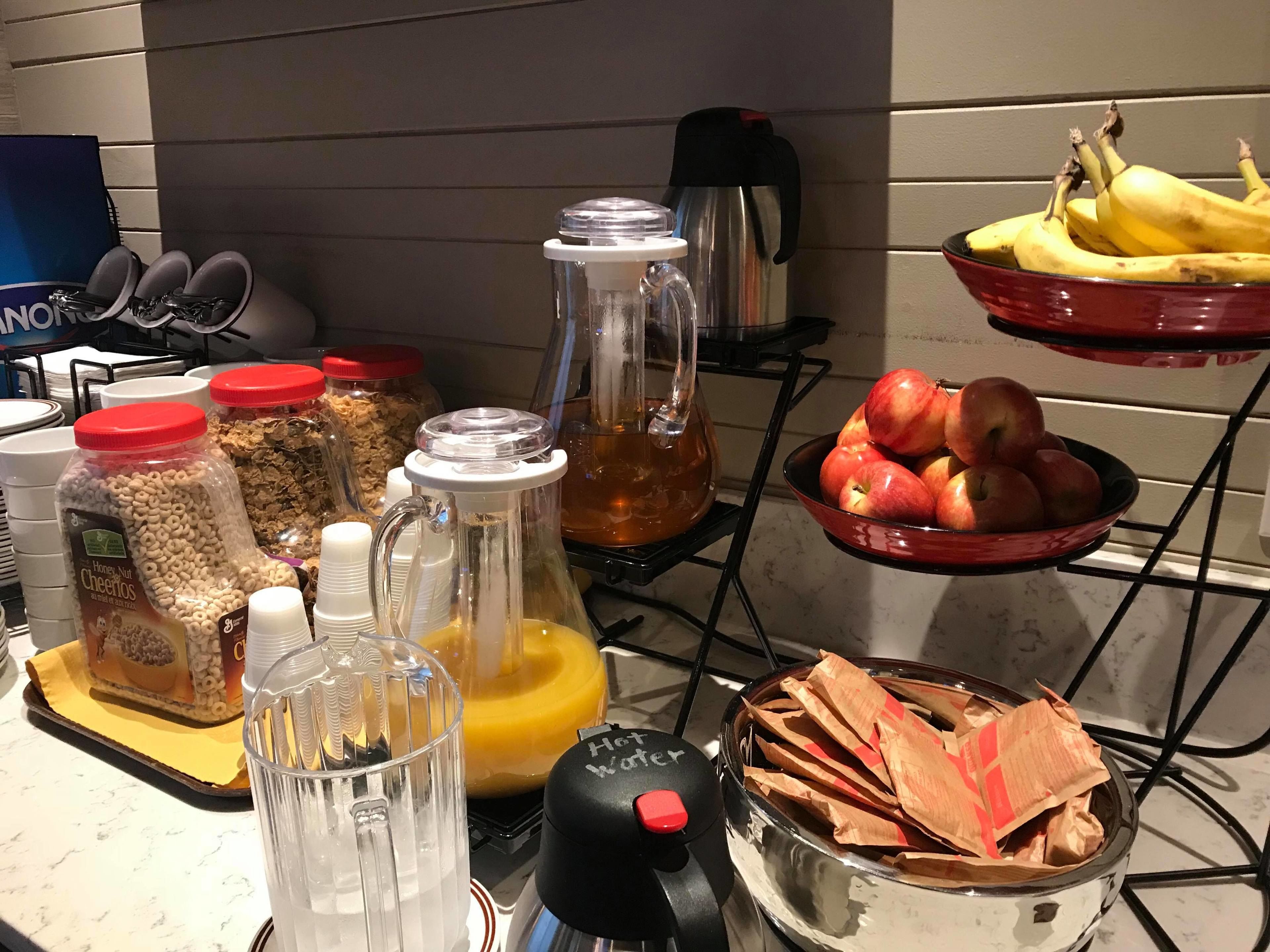 A kitchen counter with various food items and kitchen appliances.