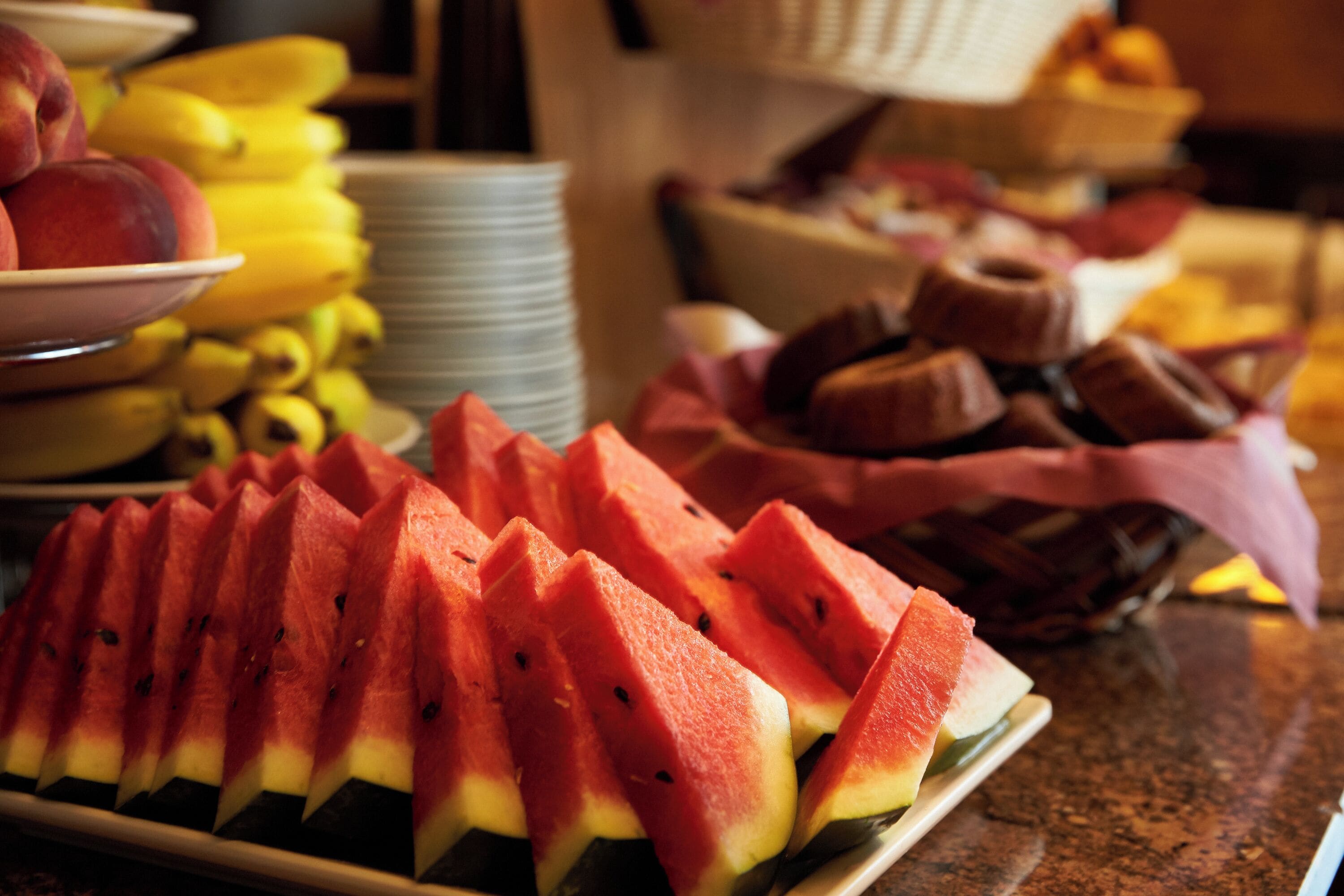 A buffet table with various fruits and pastries.