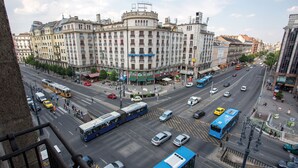 A busy urban street with a prominent building featuring multiple floors and a central entrance. - Danubius Hotel Astoria City Center (Budapest)