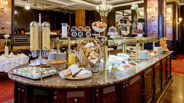 A buffet setup with various food items, including fruits, breads, and beverages. - Danubius Hotel Astoria City Center (Budapest)