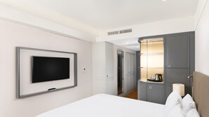 A hotel room with a bed, a TV mounted on the wall, a wardrobe, and a bedside table with a lamp. - Danubius Hotel Astoria City Center (Budapest)