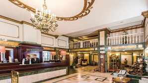 A grand lobby with a reception desk, a chandelier, and a staircase leading to an upper level. - Danubius Hotel Astoria City Center (Budapest)