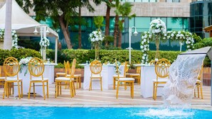 A poolside area with yellow chairs and white tables, a white tent, and a waterfall feature. - Sonesta Hotel Tower & Casino Cairo (Cairo)