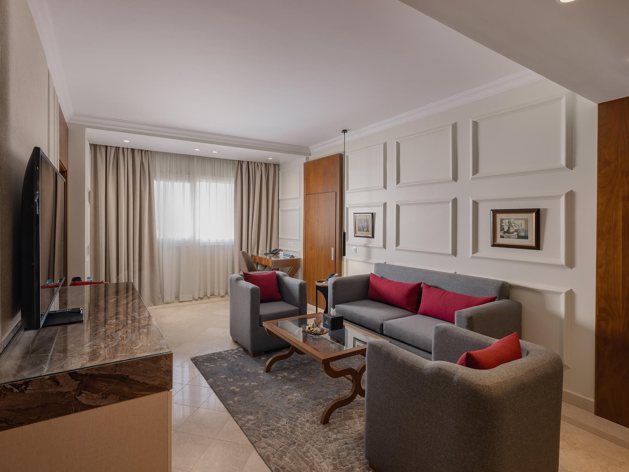 A modern living room with a sofa set, a coffee table, and a television.