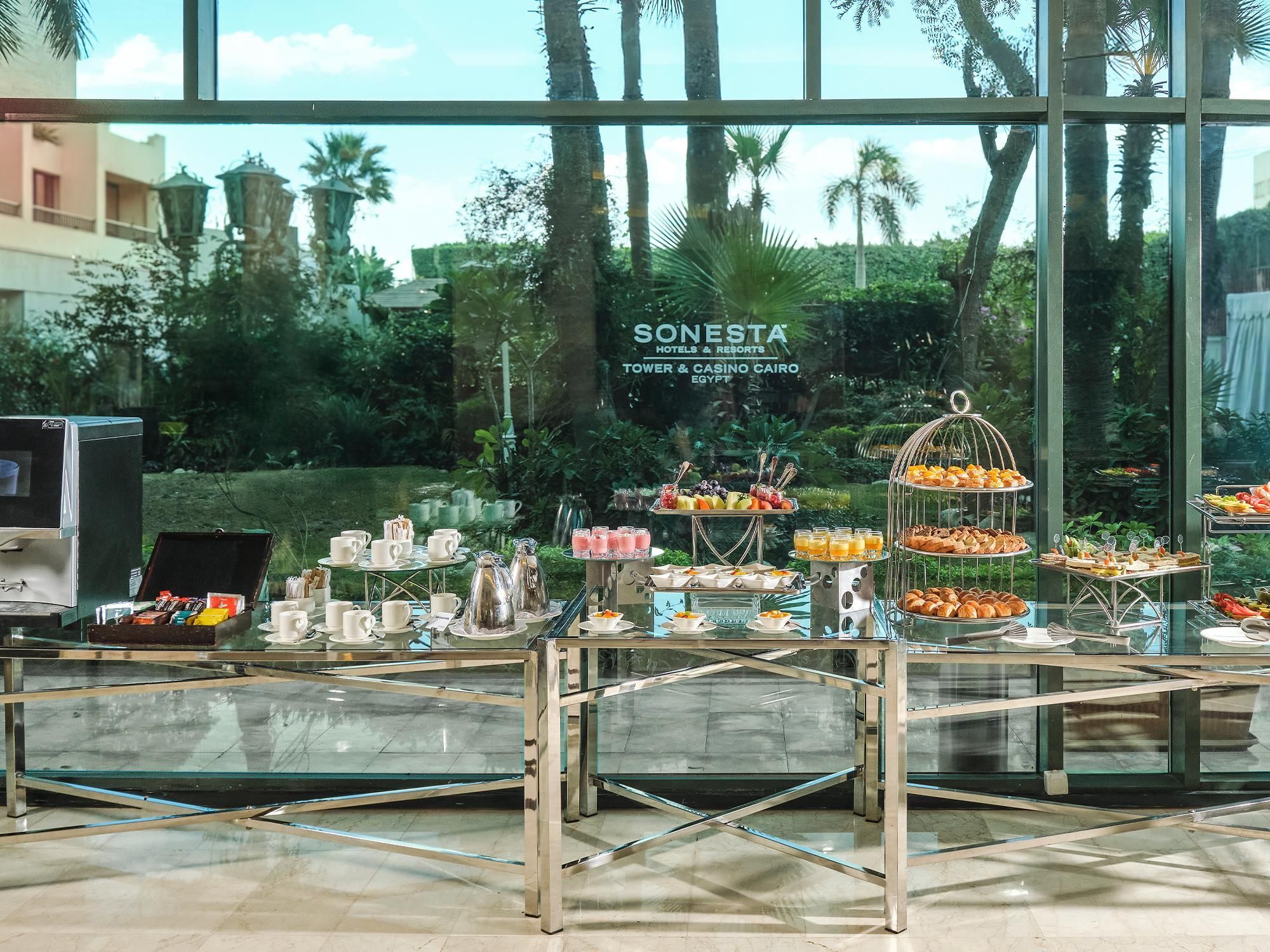 A buffet setup with various food items and a sign for Sonesta Hotels & Resorts in Cairo.