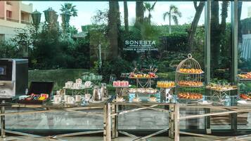 A buffet setup with various food items and a sign for Sonesta Hotels & Resorts in Cairo.