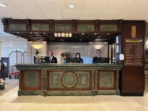 A reception desk with a marble top, a clock, and a sign indicating the concierge and reception areas. - Sonesta Hotel, Tower & Casino - Cairo (Cairo)