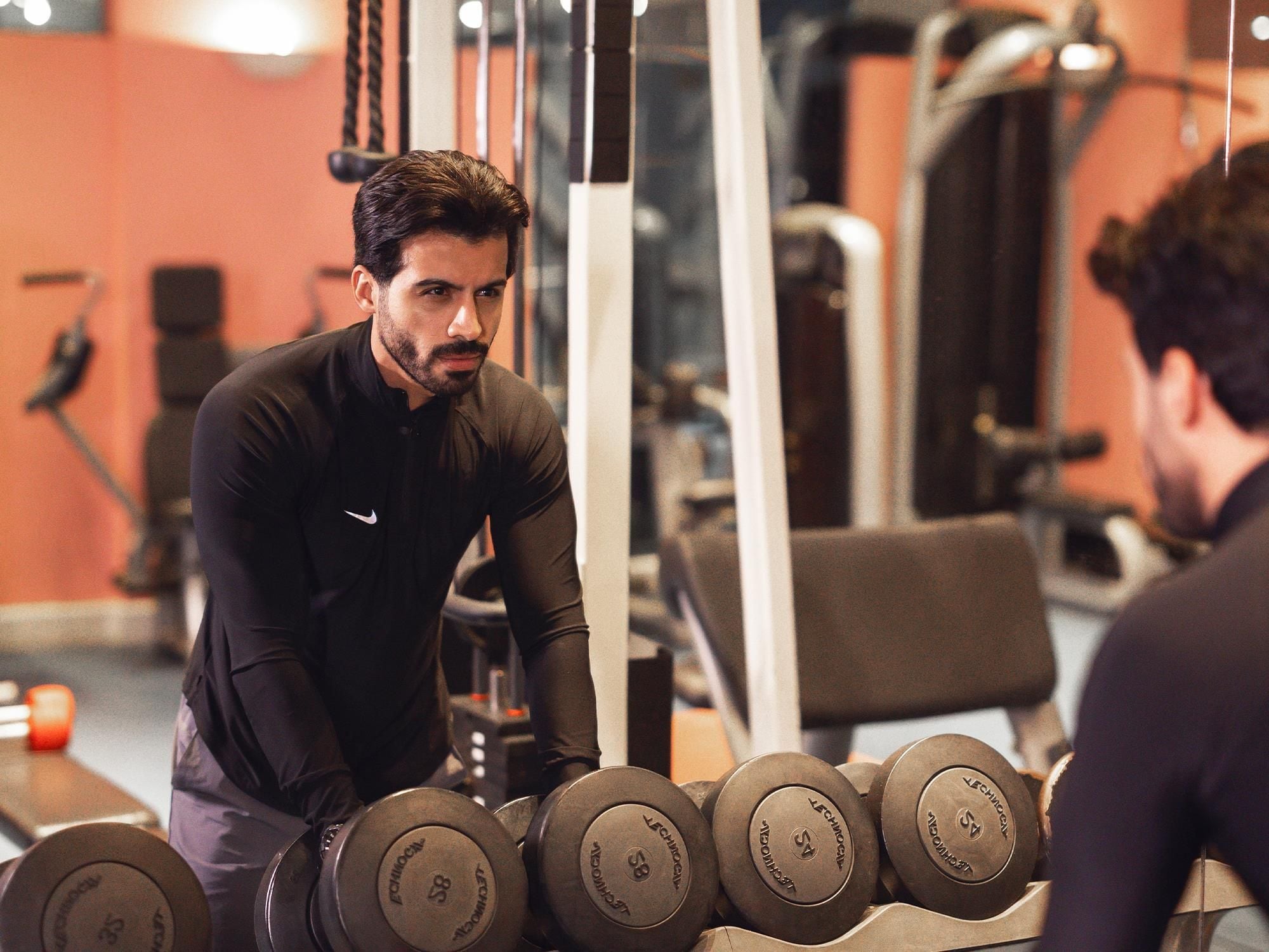 Ett gym med utrustning för styrketräning och en person som tränar.