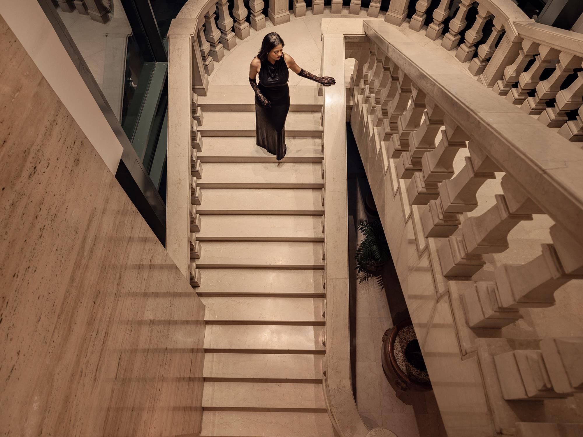 A grand staircase with a handrail and a person descending.