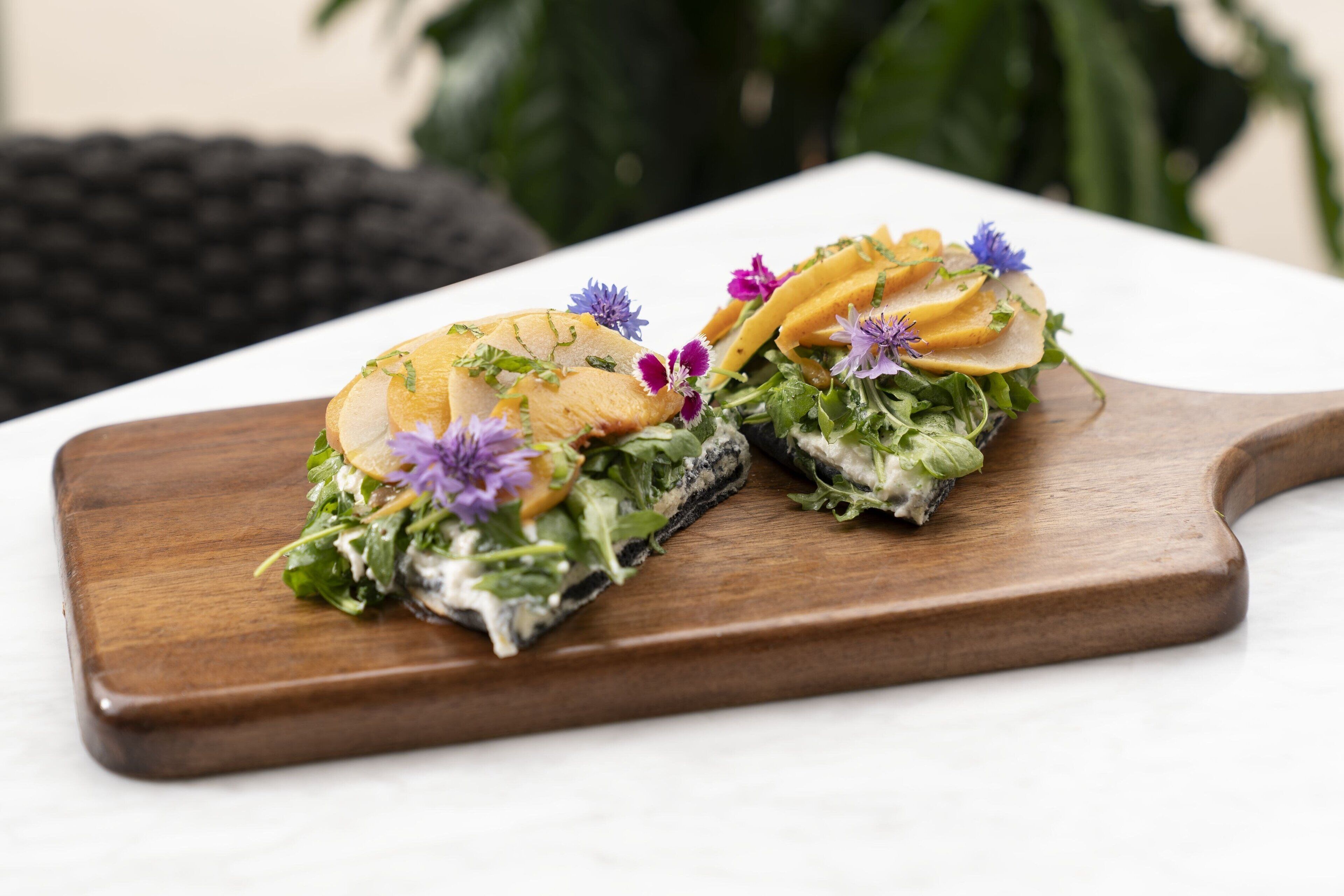Ein Holzbrett mit einem Salat darauf.