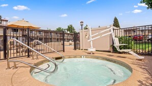 A swimming pool with a metal ladder and a gated entrance.