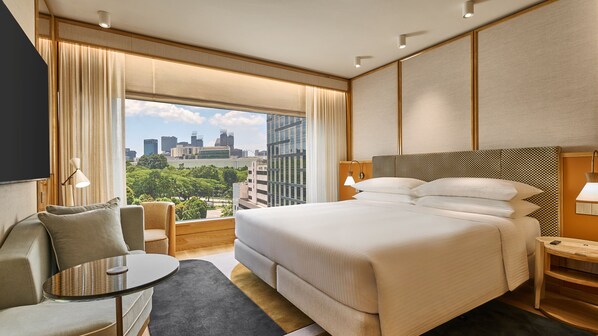 A hotel room with a large bed, a desk, a chair, and a view of the cityscape. - Holiday Inn Singapore Orchard City Centre by IHG (Singapore)