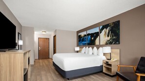 A hotel room with a large bed, a desk, a chair, a TV, and artwork on the wall. - Days Inn by Wyndham Spearfish (Spearfish)