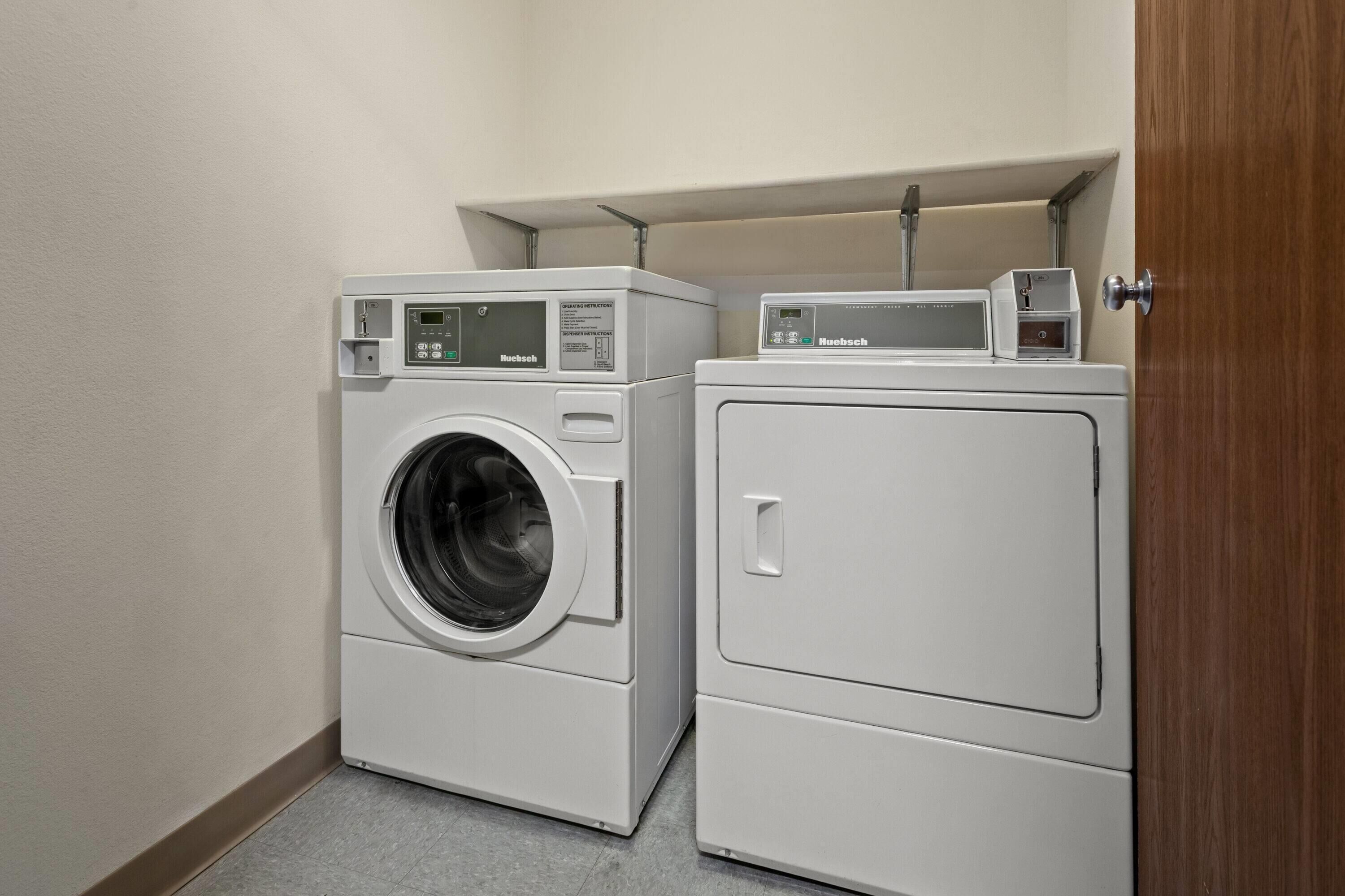 A laundry room with a front-loading washer and a top-loading dryer.