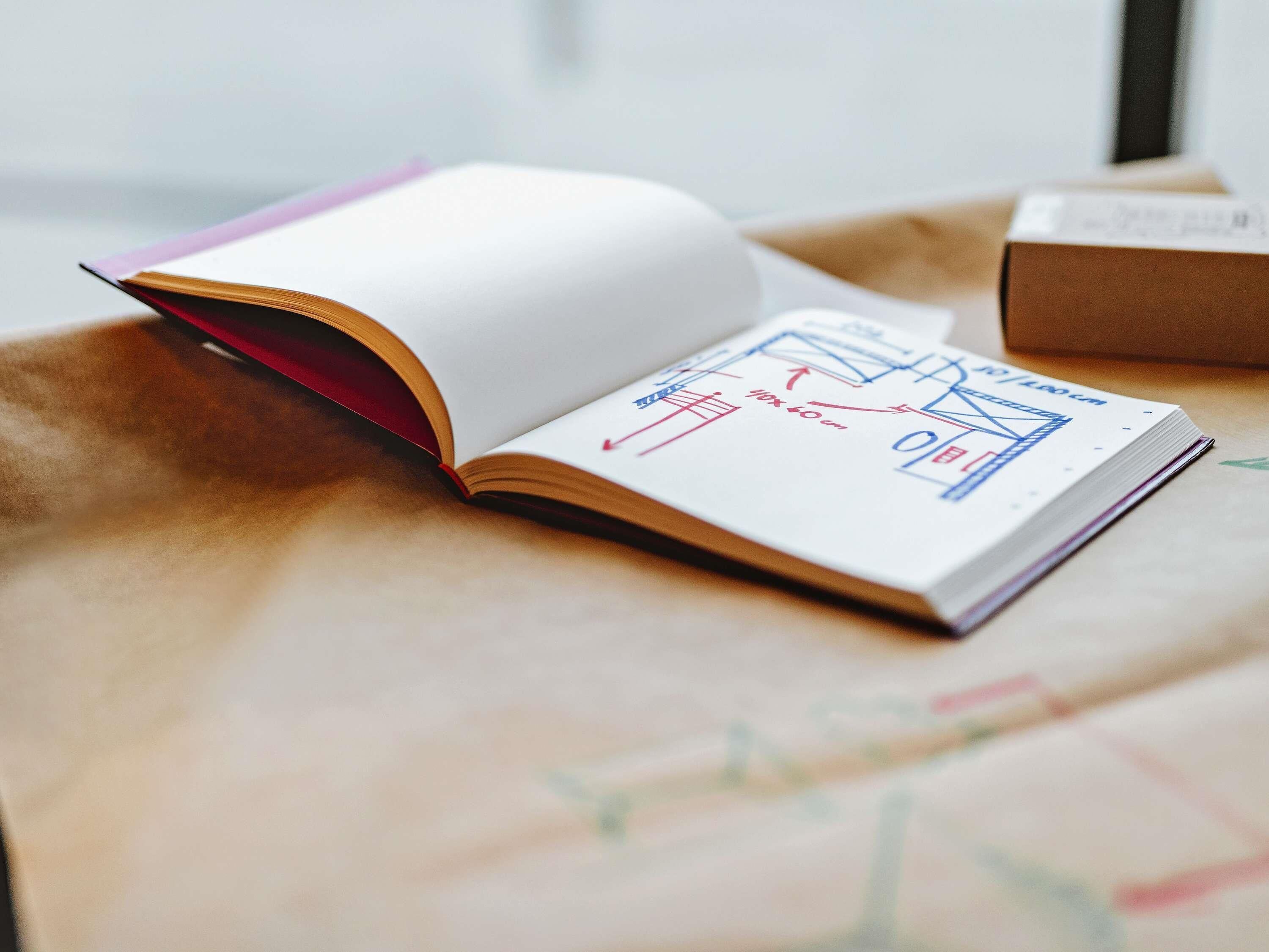 An open book with architectural drawings on a table.