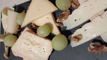 Una tabla de quesos con diferentes tipos de queso, uvas y nueces.