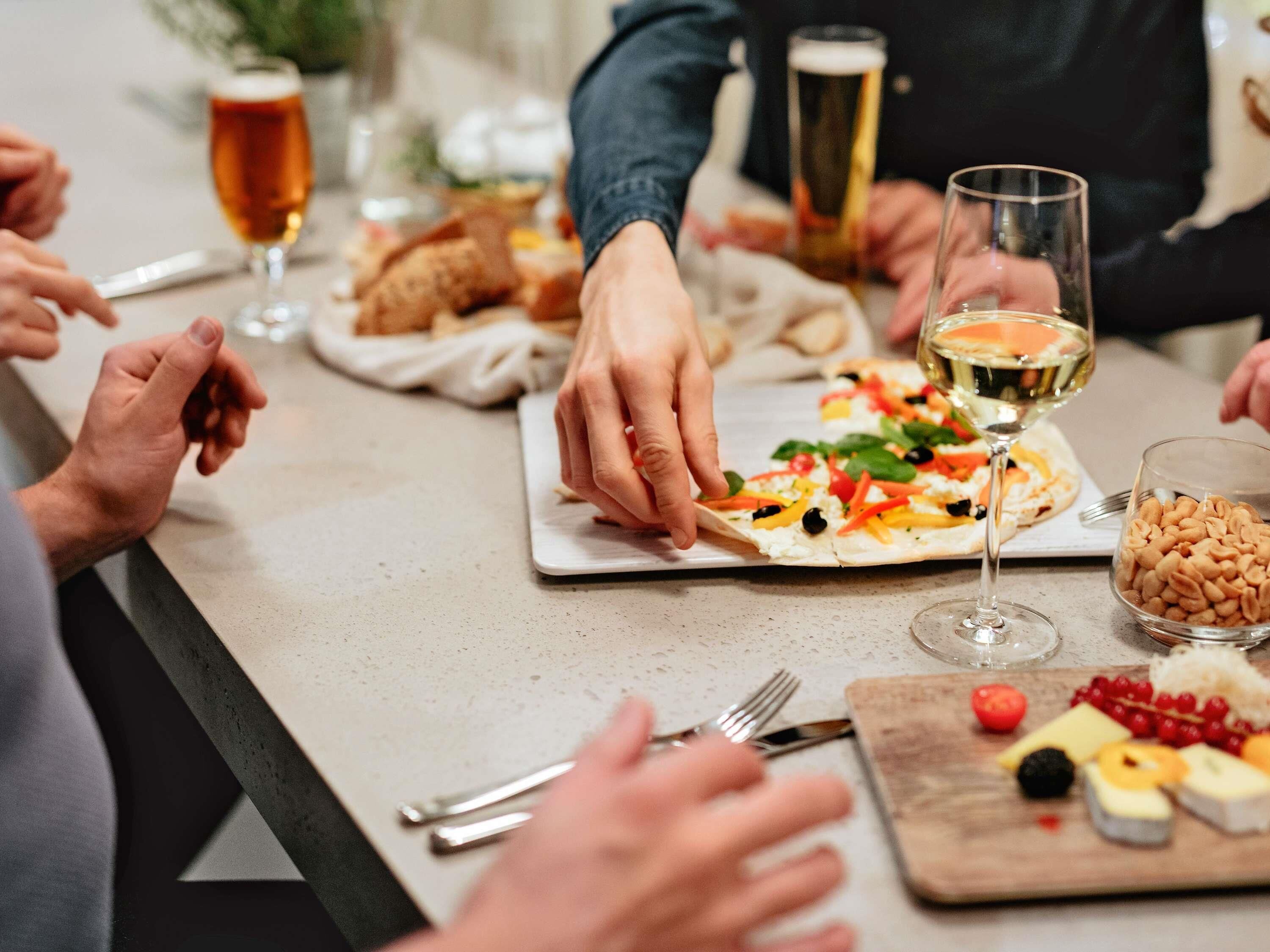 A dining table with food, wine glasses, and utensils.