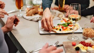 A dining table with food, wine glasses, and utensils.