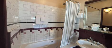 Ein Badezimmer mit einer Badewanne, einer Duschvorhang, einem Waschbecken und einem Spiegel.