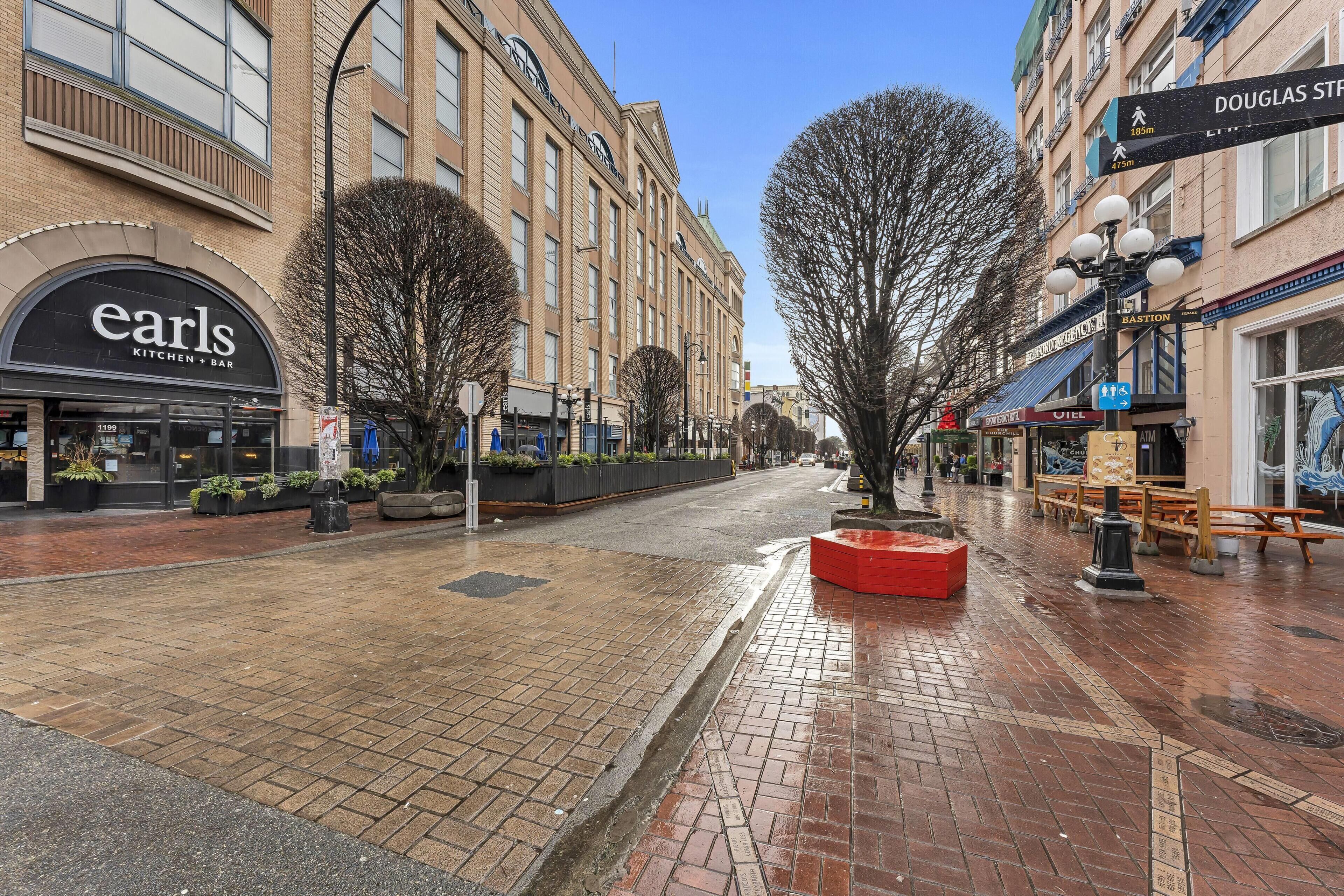 A street with a restaurant named 'earls' and a building with a sign for 'Douglas Street.'