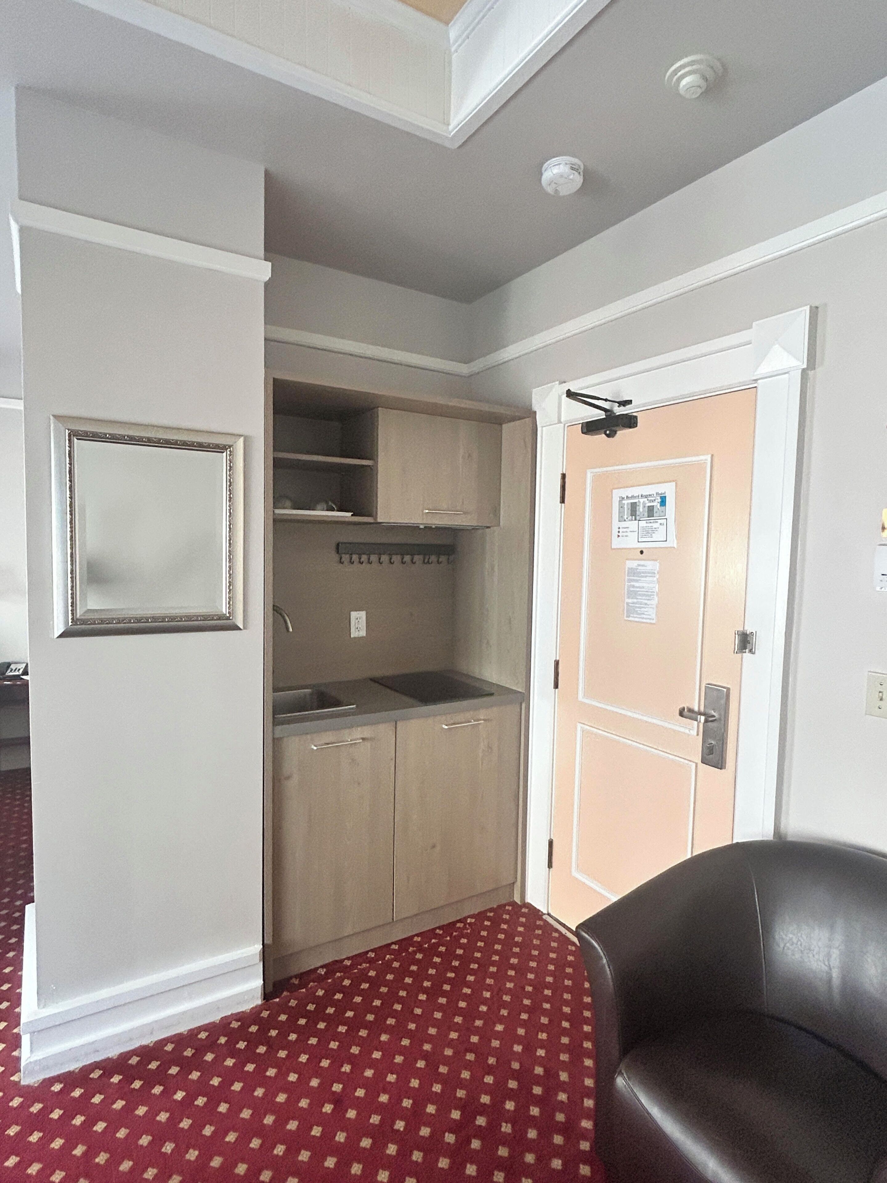 A compact kitchenette with a sink, cabinets, and a small countertop.