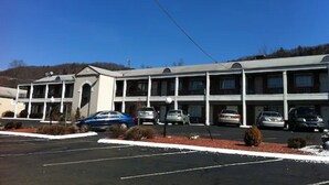 Een motel met meerdere verdiepingen en een parkeerplaats.