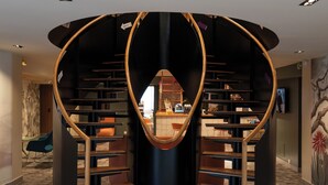 A modern interior with a circular staircase, wooden flooring, and a central seating area. - Mercure Perpignan Centre (Perpignan)