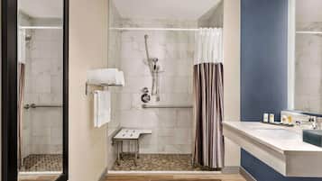 Een moderne badkamer met een douche, een wastafel en een spiegel.