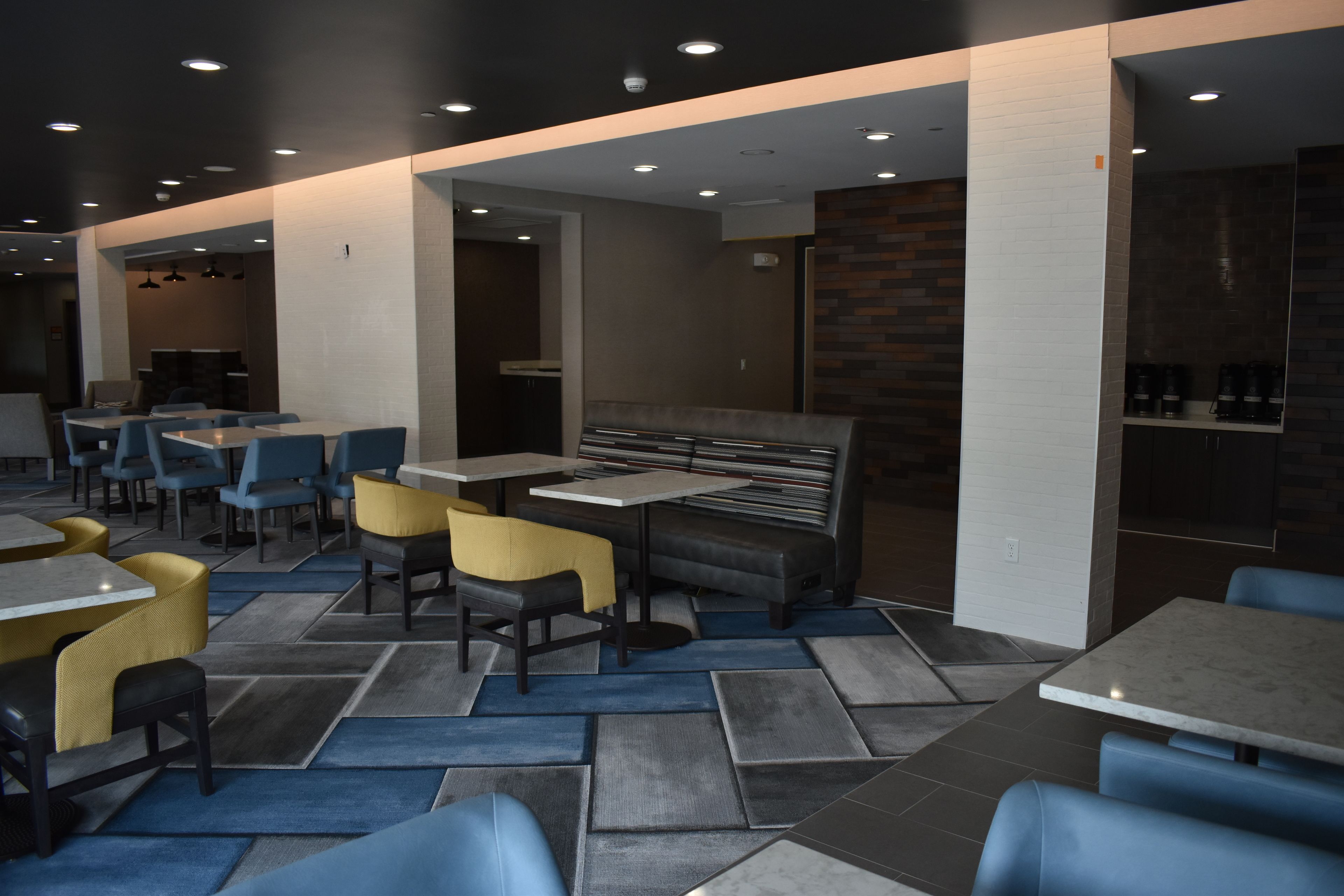 A modern restaurant interior with a variety of seating options including tables, booths, and high-top tables.