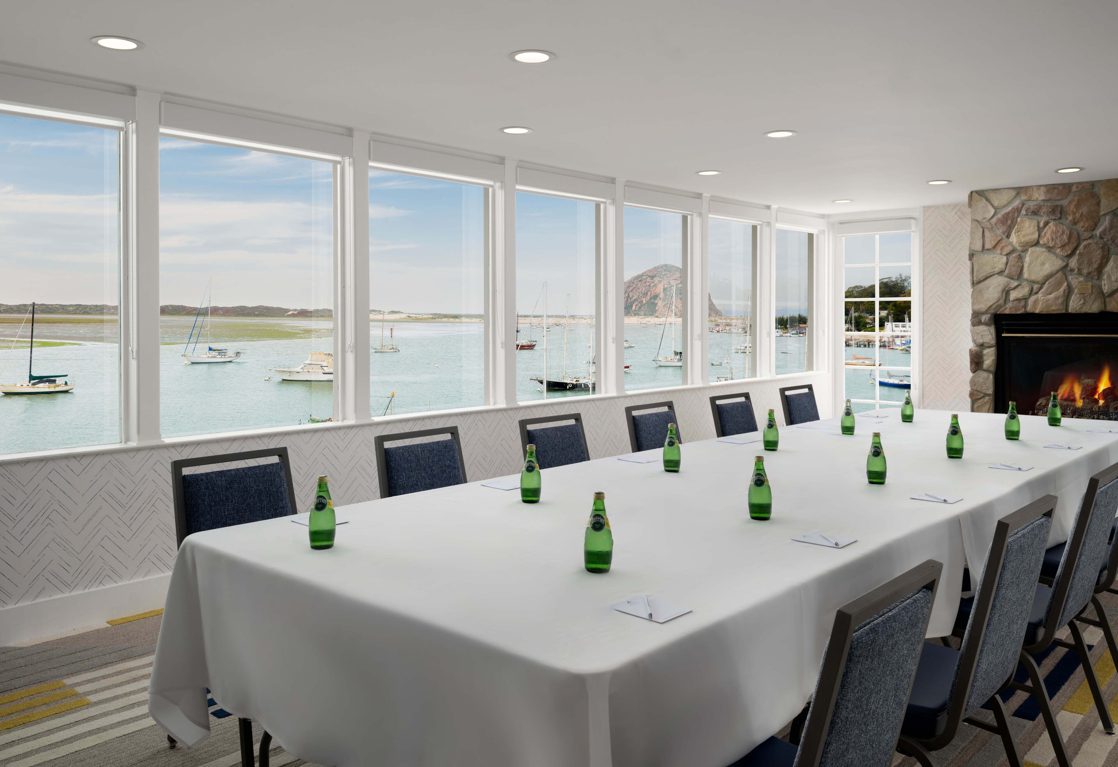 A conference room with a long table, chairs, and a fireplace.