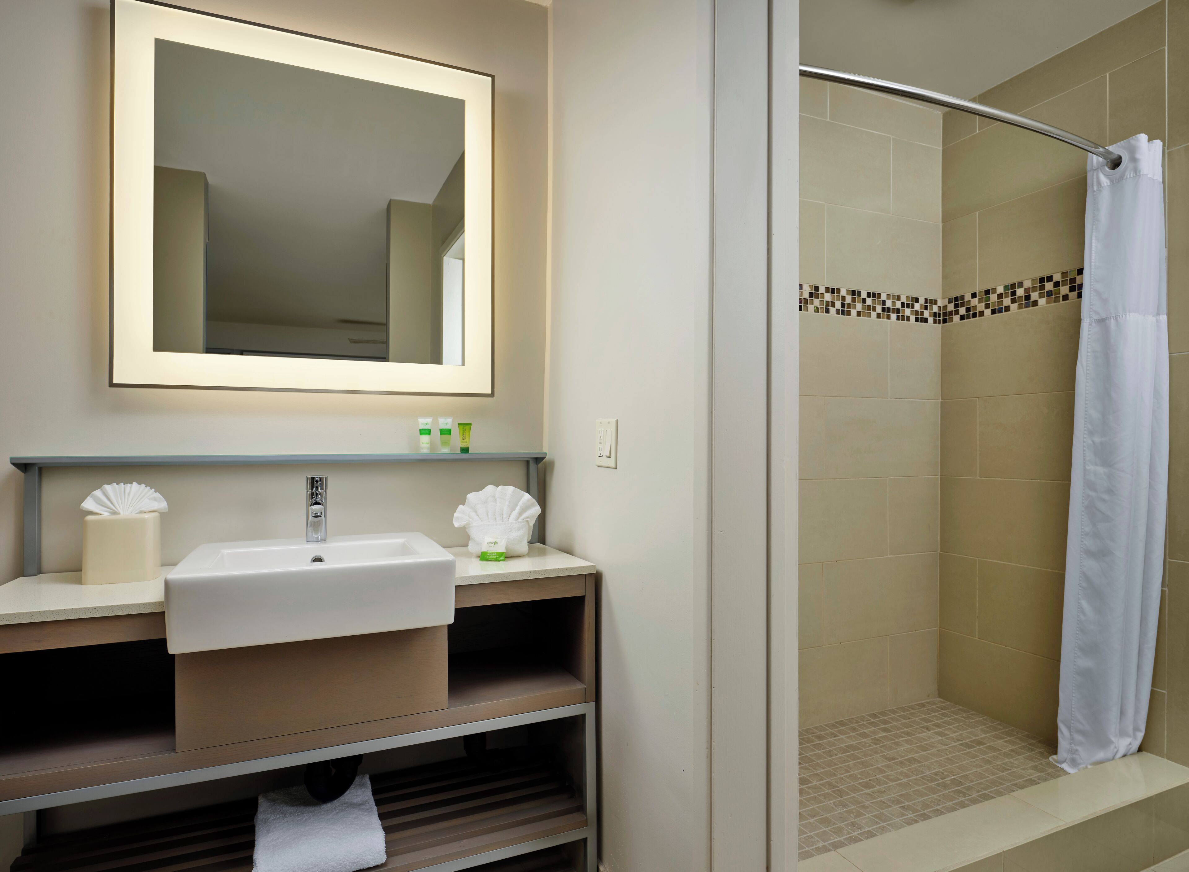 Ein Badezimmer mit Waschbecken, Spiegel und Dusche.