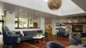 A spacious living area with a fireplace, comfortable seating, and a large window overlooking greenery.