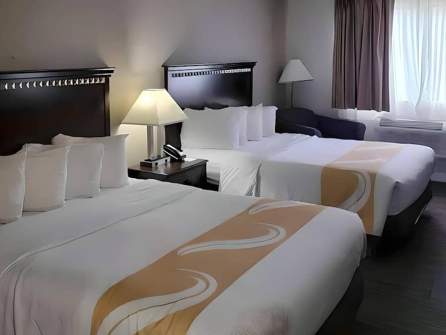 Escritorio, cortinas opacas, tabla de planchar con plancha