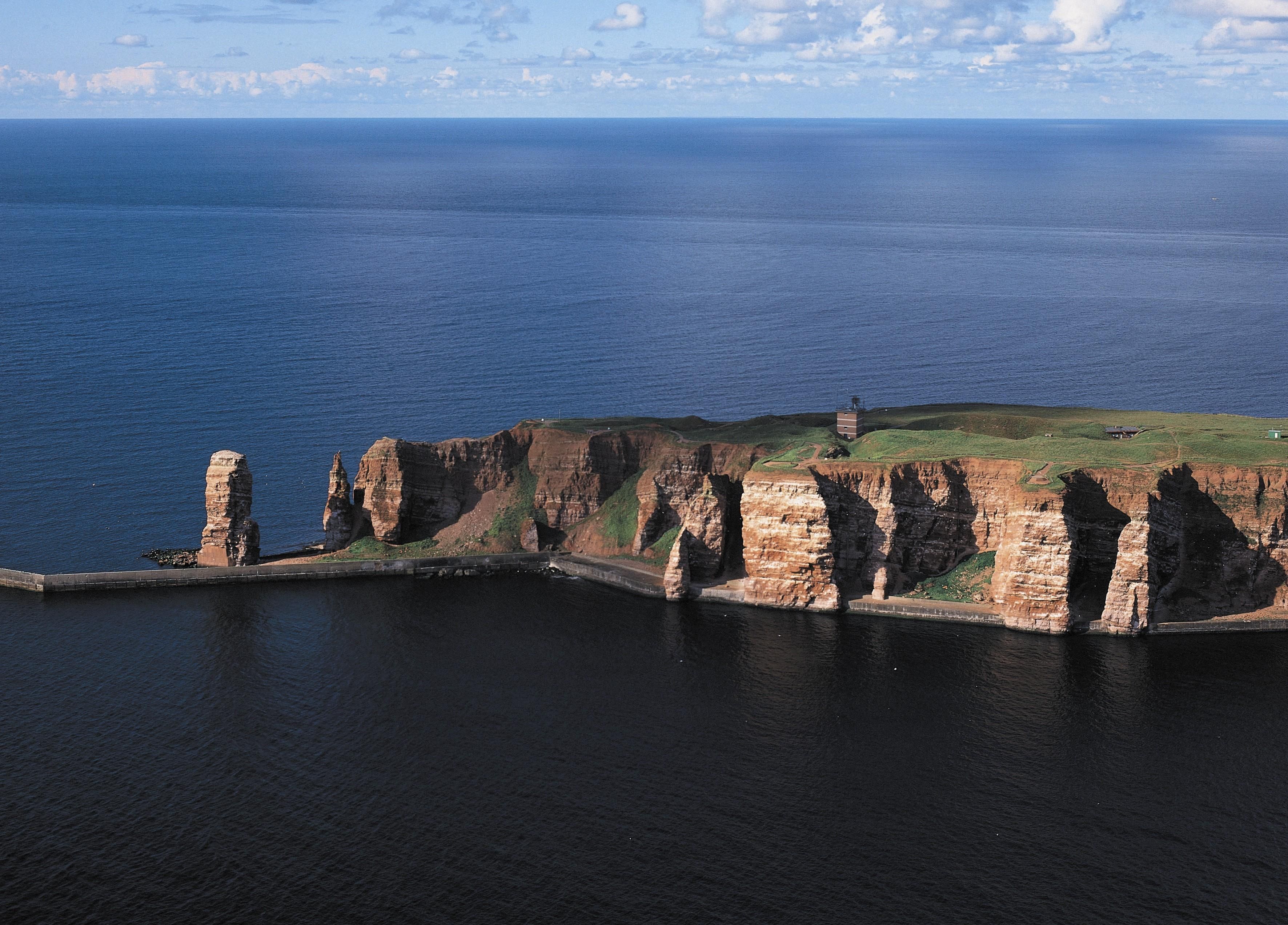 A coastal landscape with cliffs and a lighthouse.