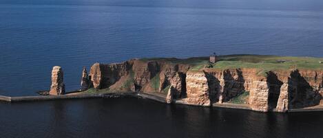 A coastal landscape with cliffs and a lighthouse.