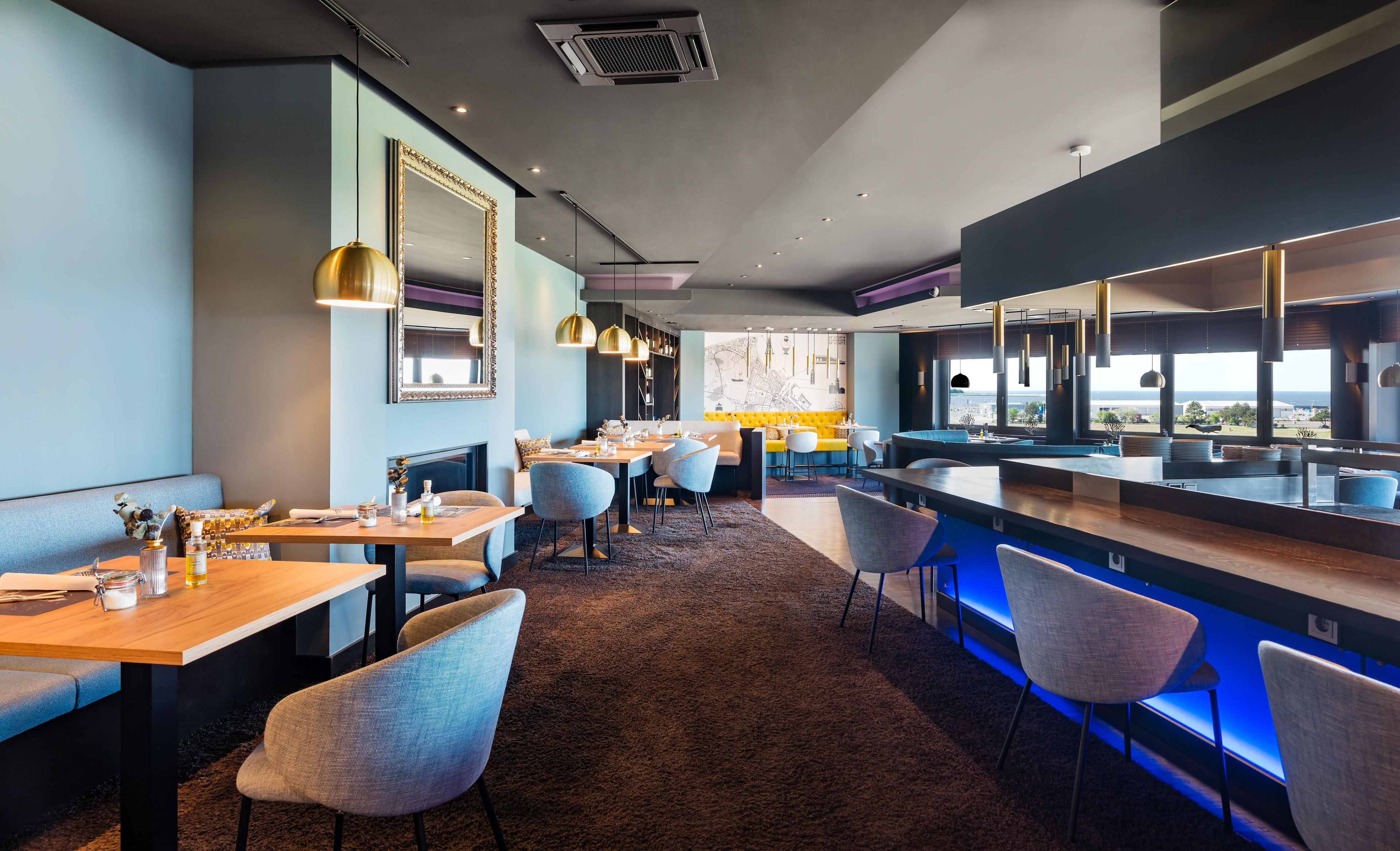 Ein modernes Restaurant-Interieur mit Barbereich, Sitzgelegenheiten und Blick nach außen.